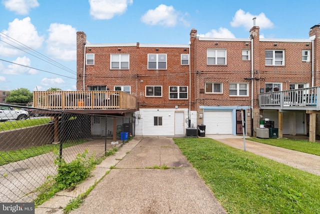 1171 E Sharpnack St, Philadelphia, PA 19150 - rear view of property featuring driveway, a garage, brick siding, and a deck
