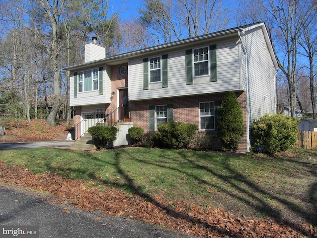 440 Tumbleweed Trl, Lusby, MD 20657 - raised ranch with a chimney, brick siding, a front lawn, and a garage