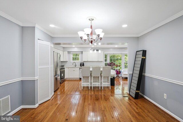 9126 Fisteris Ct, Springfield, VA 22152 - dining space with a chandelier, wood-type flooring, healthy amount of natural light, ornamental molding, and recessed lighting