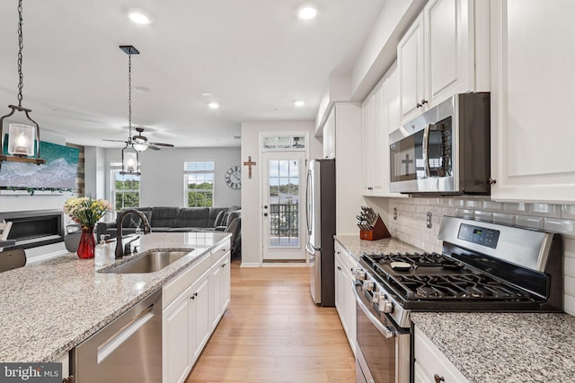 269 High Rail Ter SE, Leesburg, VA 20175 - kitchen with stainless steel appliances, open floor plan, light wood-style floors, white cabinetry, and recessed lighting