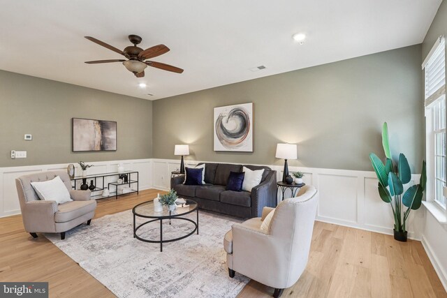 269 High Rail Ter SE, Leesburg, VA 20175 - living room featuring wood finished floors, a ceiling fan, wainscoting, and a decorative wall