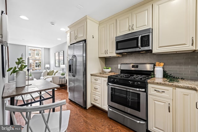 503 E Fort Ave, Baltimore, MD 21230 - kitchen featuring appliances with stainless steel finishes, cream cabinets, dark wood-style floors, backsplash, and open floor plan