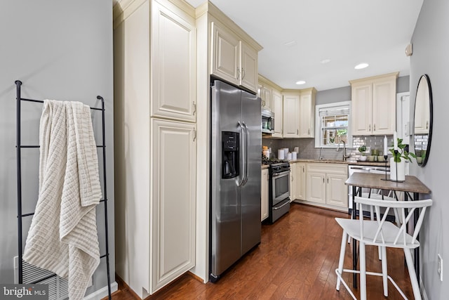 503 E Fort Ave, Baltimore, MD 21230 - kitchen with appliances with stainless steel finishes, dark wood-style floors, tasteful backsplash, cream cabinets, and recessed lighting