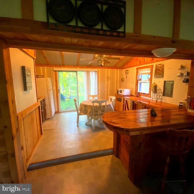 1074 White Pine Ln, Capon Bridge, WV 26711 - dining room featuring wood walls, a ceiling fan, and light flooring