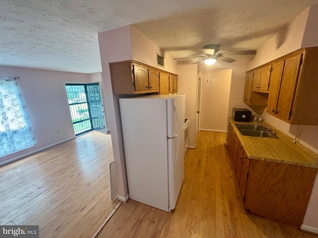 311 Ash Hollow Dr, Winchester, VA 22602 - kitchen featuring freestanding refrigerator, a textured ceiling, light wood finished floors, a ceiling fan, and brown cabinets