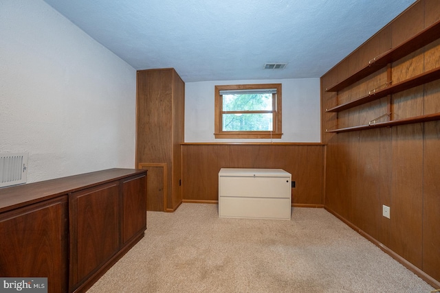 643 Crestwood Rd, Wayne, PA 19087 - unfurnished bedroom featuring a textured ceiling, wood walls, light carpet, and fridge