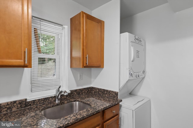 618 Cabin Branch Dr, Capitol Heights, MD 20743 - kitchen featuring stacked washer / dryer, dark stone counters, and brown cabinetry