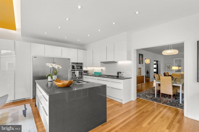 2815 39th St NW, Washington, DC 20007 - kitchen featuring dark countertops, stainless steel appliances, white cabinets, modern cabinets, and light wood-style floors