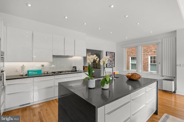 2815 39th St NW, Washington, DC 20007 - kitchen featuring modern cabinets, dark countertops, white cabinets, light wood-type flooring, and recessed lighting