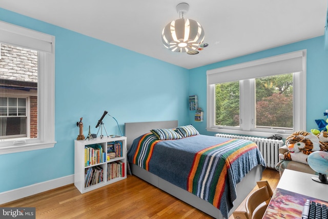 2815 39th St NW, Washington, DC 20007 - bedroom featuring radiator heating unit, a chandelier, and wood finished floors