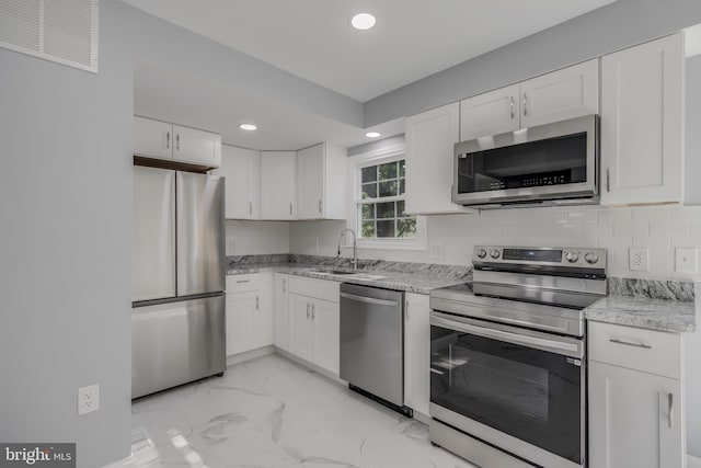 902 Nadine Ct, Landover, MD 20785 - kitchen with appliances with stainless steel finishes, recessed lighting, light marble finish flooring, white cabinetry, and light stone counters