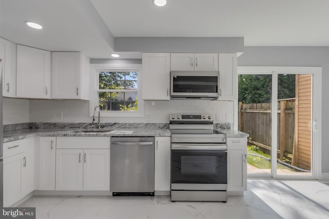 902 Nadine Ct, Landover, MD 20785 - kitchen featuring appliances with stainless steel finishes, light marble finish flooring, recessed lighting, white cabinets, and light stone counters