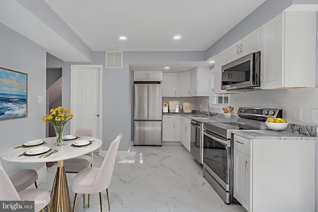902 Nadine Ct, Landover, MD 20785 - kitchen with appliances with stainless steel finishes, light marble finish floors, white cabinets, light stone countertops, and recessed lighting