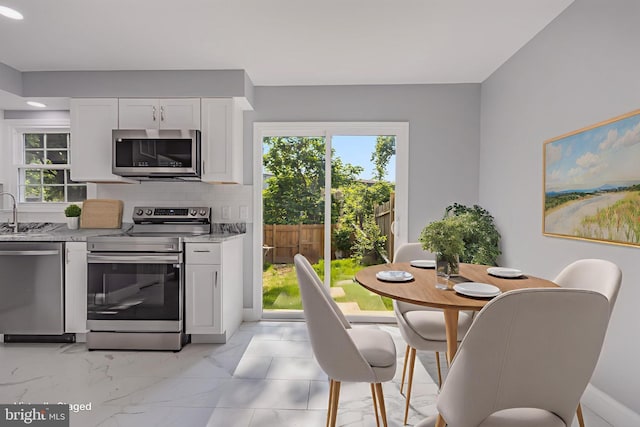 902 Nadine Ct, Landover, MD 20785 - kitchen featuring stainless steel appliances, light stone countertops, white cabinetry, plenty of natural light, and recessed lighting