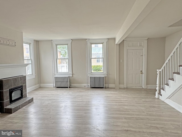 112 Dorman St, Harrington, DE 19952 - unfurnished living room featuring radiator heating unit, stairway, and wood finished floors