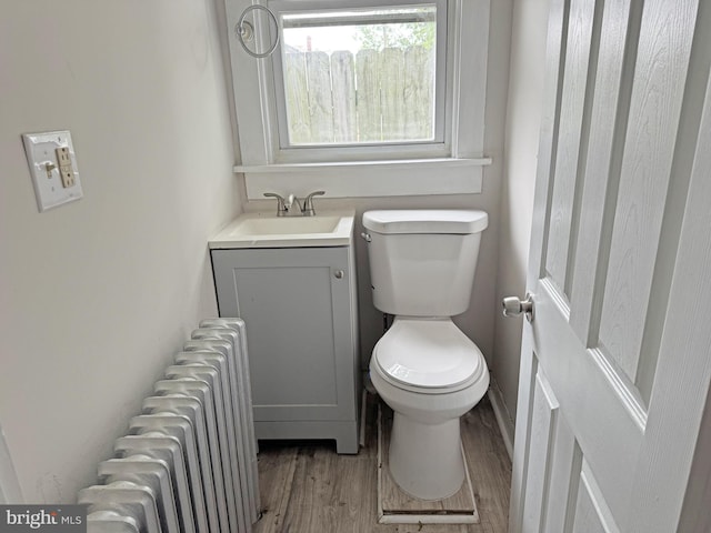 112 Dorman St, Harrington, DE 19952 - bathroom with radiator heating unit, wood finished floors, and vanity