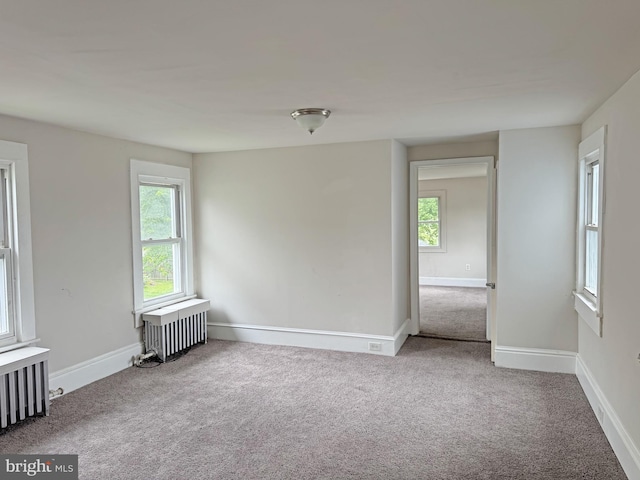 112 Dorman St, Harrington, DE 19952 - carpeted empty room with radiator heating unit and plenty of natural light