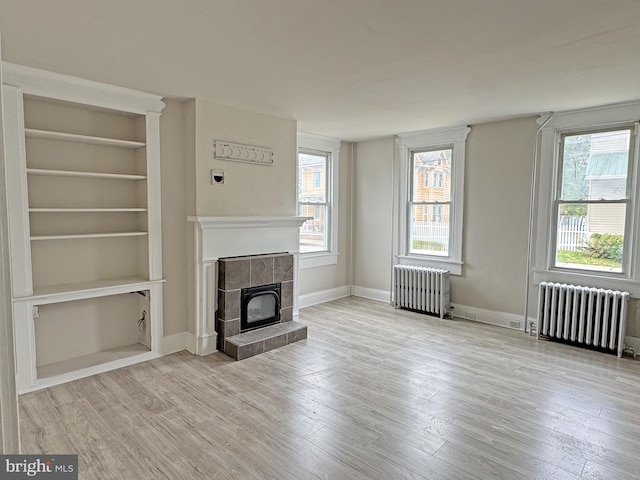 112 Dorman St, Harrington, DE 19952 - unfurnished living room featuring radiator heating unit, a tile fireplace, and wood finished floors