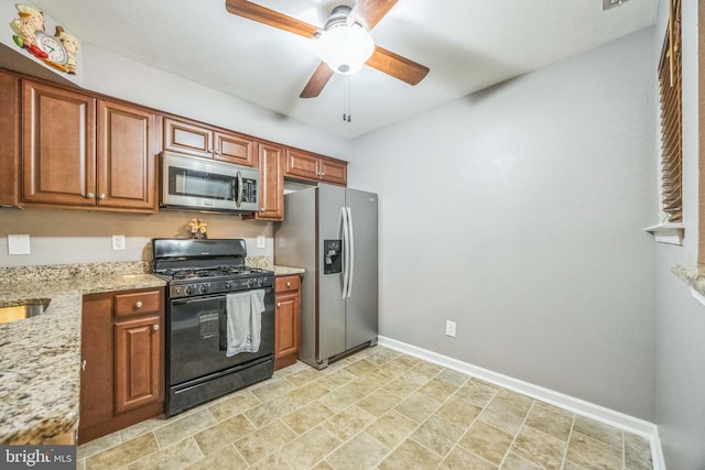 1043 Tristram Cir, Mantua, NJ 08051 - kitchen with appliances with stainless steel finishes, light stone countertops, ceiling fan, brown cabinetry, and stone finish floors