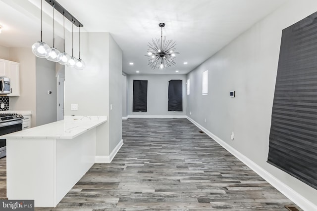 4219 Granada Ave, Baltimore, MD 21215 - kitchen with appliances with stainless steel finishes, wood finished floors, a chandelier, white cabinets, and recessed lighting