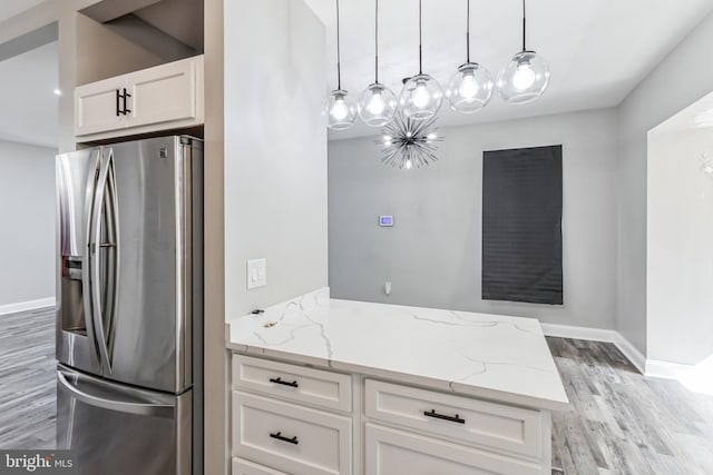 4219 Granada Ave, Baltimore, MD 21215 - kitchen featuring stainless steel fridge with ice dispenser, light wood finished floors, white cabinets, light stone counters, and a peninsula