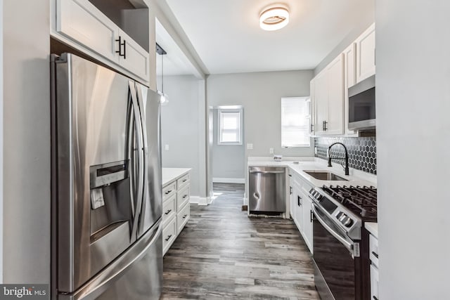4219 Granada Ave, Baltimore, MD 21215 - kitchen with appliances with stainless steel finishes, white cabinetry, light countertops, dark wood-style flooring, and backsplash