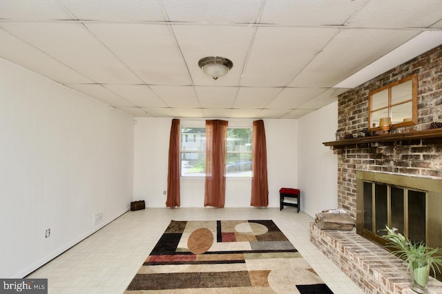 12518 Tove Rd, Clinton, MD 20735 - living room featuring a paneled ceiling, tile patterned floors, and a brick fireplace