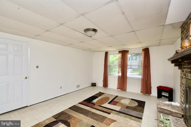 12518 Tove Rd, Clinton, MD 20735 - unfurnished living room featuring tile patterned floors, a paneled ceiling, and a glass covered fireplace
