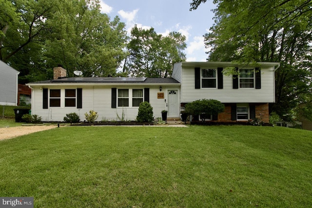 12518 Tove Rd, Clinton, MD 20735 - split level home featuring roof mounted solar panels, a front yard, and a chimney