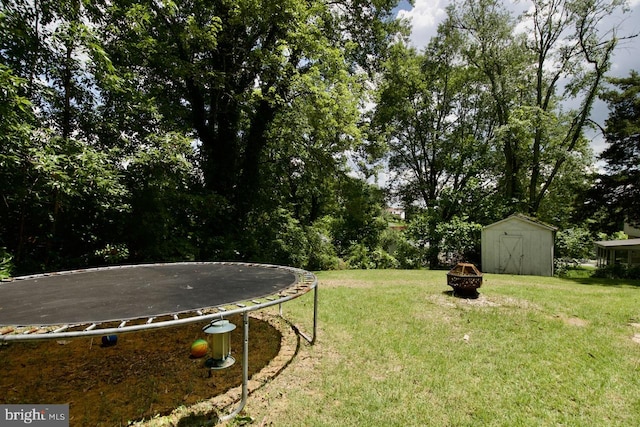 12518 Tove Rd, Clinton, MD 20735 - view of green lawn with a trampoline, a storage unit, and an outdoor fire pit