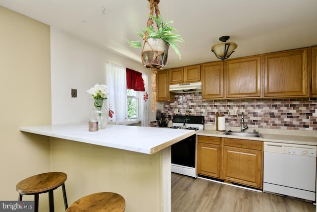 12518 Tove Rd, Clinton, MD 20735 - kitchen featuring white appliances, under cabinet range hood, a breakfast bar area, and backsplash