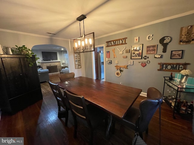 7301 Granite Rd, Elkins Park, PA 19027 - dining room featuring arched walkways, dark wood-style floors, crown molding, a chandelier, and a fireplace