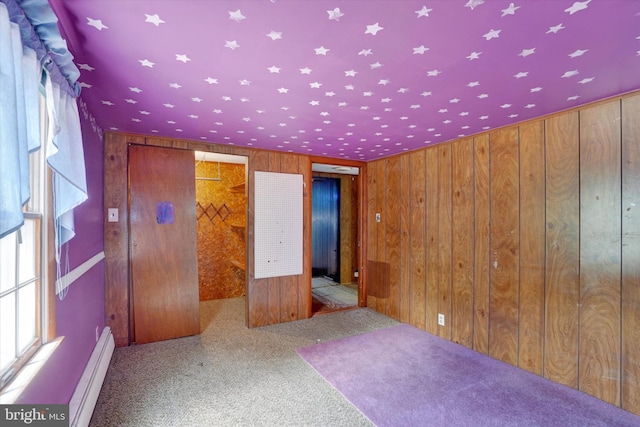 2605 N Sherman St, York, PA 17406 - empty room with a baseboard radiator, wooden walls, plenty of natural light, and carpet flooring