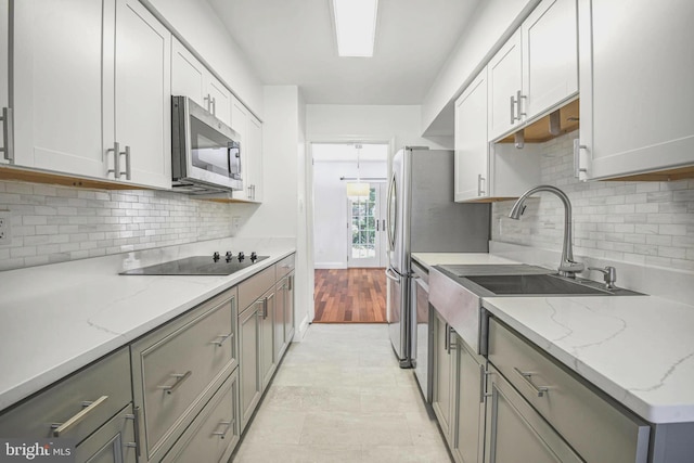 7809 Heatherton Ln, Potomac, MD 20854 - kitchen with appliances with stainless steel finishes, backsplash, light stone counters, and gray cabinetry