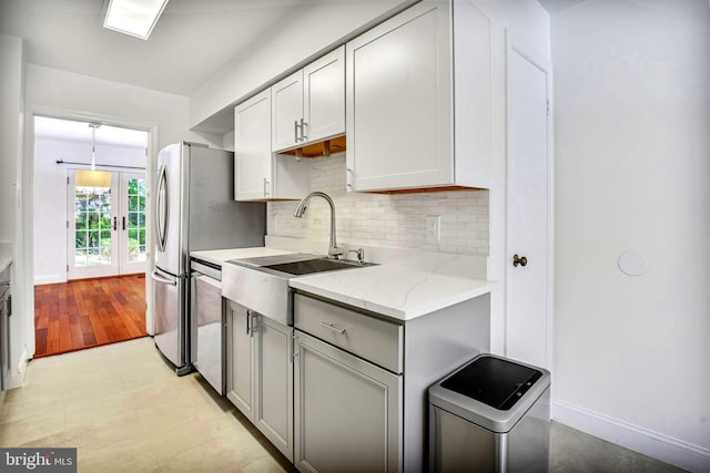 7809 Heatherton Ln, Potomac, MD 20854 - kitchen with dishwasher, decorative backsplash, light stone countertops, french doors, and gray cabinetry