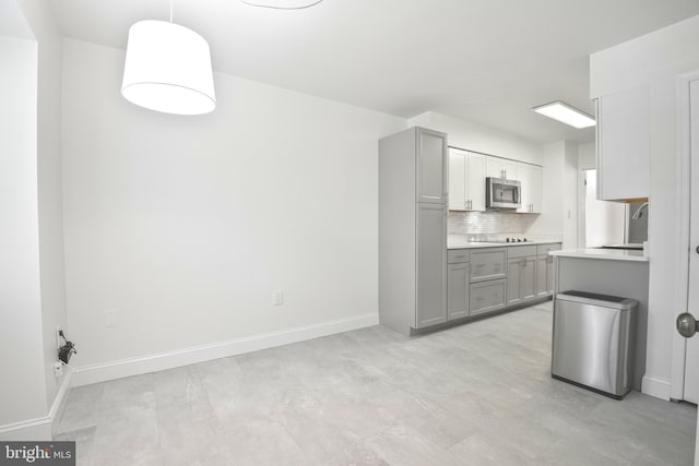 7809 Heatherton Ln, Potomac, MD 20854 - kitchen with stainless steel microwave, gray cabinets, light countertops, decorative backsplash, and black electric stovetop