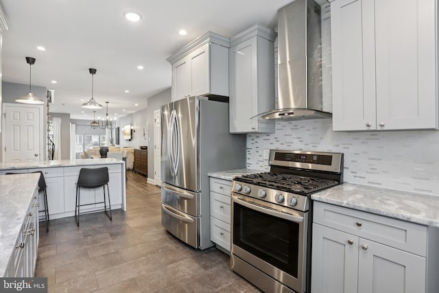 7357 E Walnut Ln, Philadelphia, PA 19138 - kitchen featuring appliances with stainless steel finishes, wall chimney range hood, open floor plan, tasteful backsplash, and a chandelier