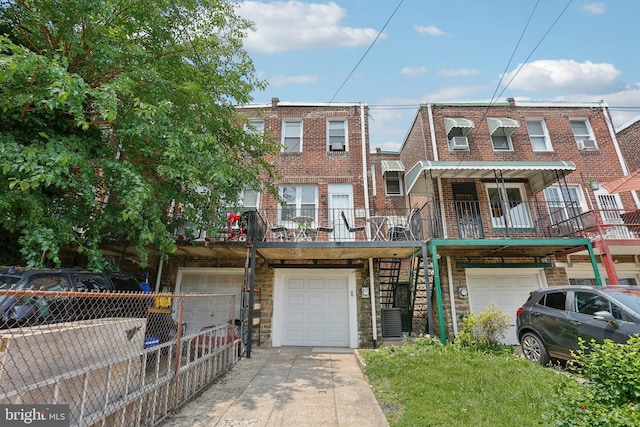 7357 E Walnut Ln, Philadelphia, PA 19138 - townhome / multi-family property with a garage, stairway, stone siding, driveway, and brick siding