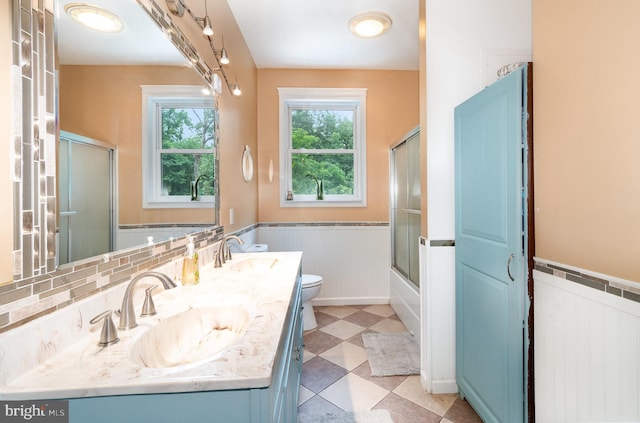 3789 Spring Rd, Carlisle, PA 17013 - full bath featuring wainscoting, double vanity, and combined bath / shower with glass door