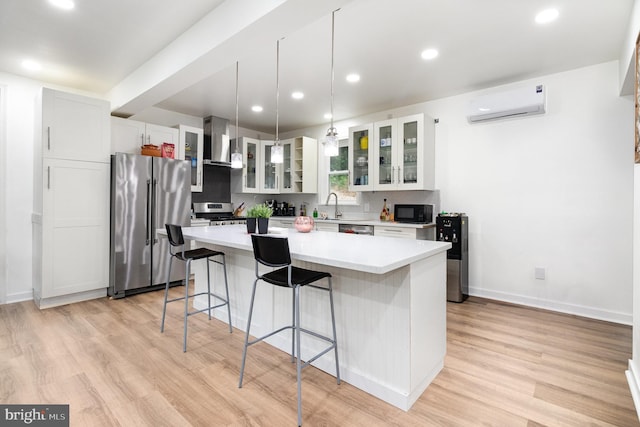 3789 Spring Rd, Carlisle, PA 17013 - kitchen featuring appliances with stainless steel finishes, an AC wall unit, a breakfast bar area, wall chimney exhaust hood, and a center island