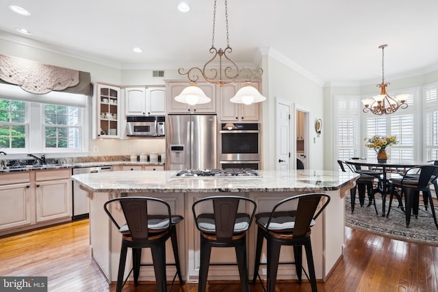 114 Lake St, Gaithersburg, MD 20878 - kitchen with stainless steel appliances, a chandelier, a kitchen island, a kitchen breakfast bar, and ornamental molding