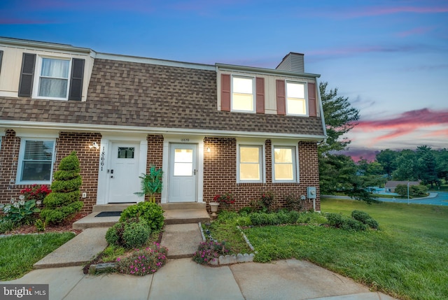 18659 Sandpiper Ln, Gaithersburg, MD 20879 - view of front of house with roof with shingles, brick siding, a chimney, and a lawn