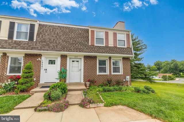 18659 Sandpiper Ln, Gaithersburg, MD 20879 - view of front facade with roof with shingles, brick siding, a chimney, and a front yard
