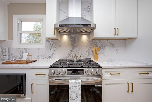 508 Vine St, Palmyra, NJ 08065 - kitchen featuring stainless steel range with gas cooktop, wall chimney exhaust hood, decorative backsplash, and white cabinetry