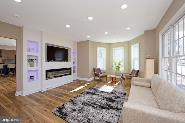 508 Vine St, Palmyra, NJ 08065 - living area featuring healthy amount of natural light, wood finished floors, a glass covered fireplace, and recessed lighting