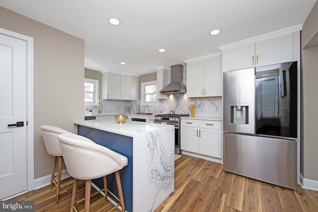 508 Vine St, Palmyra, NJ 08065 - kitchen with stainless steel appliances, wall chimney range hood, white cabinetry, light stone counters, and tasteful backsplash