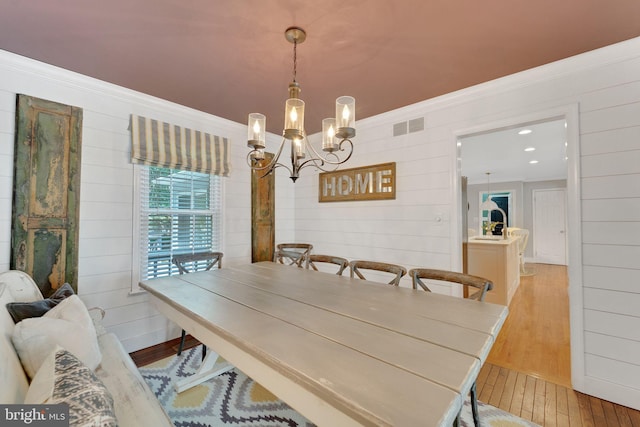 1092 Carriage Hill Pkwy, Annapolis, MD 21401 - dining room featuring a chandelier, light wood-type flooring, crown molding, and wooden walls