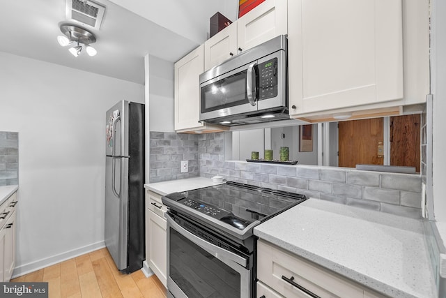 114 Naudain St Unit A, Philadelphia, PA 19147 - kitchen featuring stainless steel appliances, backsplash, white cabinets, and light wood-style flooring