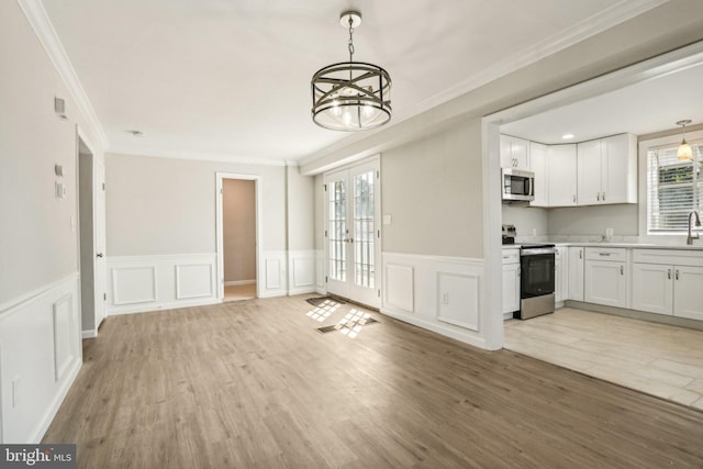 549 Madison Ave, Warminster, PA 18974 - unfurnished dining area with crown molding, plenty of natural light, a chandelier, light wood-style flooring, and wainscoting