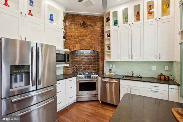 1240 Girard St NW, Washington, DC 20009 - kitchen featuring stainless steel appliances, open shelves, white cabinets, brick wall, and dark wood finished floors